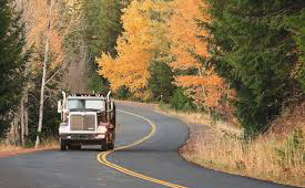 Semi Truck traveling down the road in the autumn